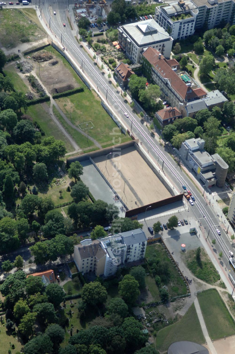 Berlin from above - Der Mauerpark ist eine Parkanlage in Berlin. Sein Name geht auf die 1961 errichtete Berliner Mauer zurück, die hier die Grenze zwischen den damaligen Bezirken Prenzlauer Berg und Wedding bildete. Heute verläuft hier die Grenze zwischen den Ortsteilen Prenzlauer Berg (Bezirk Pankow) und Gesundbrunnen (Bezirk Mitte). Im Westen liegt das zu Gesundbrunnen gehörende Brunnenviertel, im Osten das zu Prenzlauer Berg gehörende Gleimviertel. Das langgestreckte Freigelände verläuft entlang des für den Kraftverkehr gesperrten Abschnitts der Schwedter Straße zwischen Eberswalder Straße / Bernauer Straße und Ringbahn.