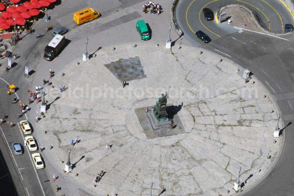 Aerial photograph München - Blick auf den Max-Joseph-Platz in München. Der Max-Joseph-Platz, benannt nach König Max I. Joseph, gehört zu Münchens bekannter Sehenswürdigkeit. Mit Standbild von Max I. Joseph und dem Bayerischen Nationaltheater ist eine Architektur gelungen, die diesem Platz Theatralik und Ausdruck verleiht. Der Max Joseph Platz dient als beliebter Dreh und Angelpunkt von Touristen, Verliebte und Konzertbesucher. Die Maximilianstraße in München ist neben der Brienner Straße, der Ludwigstraße und der Prinzregentenstraße eine der vier städtebaulich bedeutendsten Prachtstraßen der Stadt aus dem 19. Jh. Die Maximilianstraße beginnt am Max-Joseph-Platz und verläuft absolut gerade in südöstlicher Richtung zur Isar. Der Architekturstil, der Elemente verschiedener Stilepochen wie Neogotik und Renaissance vereint, stieß auf viel Kritik, macht die Maximilianstraße jedoch städtebaulich einzigartig in München. In neuerer Zeit hat sich die Straße den Ruf einer mondänen und teuren Einkaufsmeile erworben.