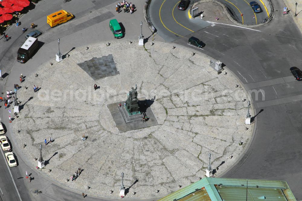 München from above - Blick auf den Max-Joseph-Platz in München. Der Max-Joseph-Platz, benannt nach König Max I. Joseph, gehört zu Münchens bekannter Sehenswürdigkeit. Mit Standbild von Max I. Joseph und dem Bayerischen Nationaltheater ist eine Architektur gelungen, die diesem Platz Theatralik und Ausdruck verleiht. Der Max Joseph Platz dient als beliebter Dreh und Angelpunkt von Touristen, Verliebte und Konzertbesucher. Die Maximilianstraße in München ist neben der Brienner Straße, der Ludwigstraße und der Prinzregentenstraße eine der vier städtebaulich bedeutendsten Prachtstraßen der Stadt aus dem 19. Jh. Die Maximilianstraße beginnt am Max-Joseph-Platz und verläuft absolut gerade in südöstlicher Richtung zur Isar. Der Architekturstil, der Elemente verschiedener Stilepochen wie Neogotik und Renaissance vereint, stieß auf viel Kritik, macht die Maximilianstraße jedoch städtebaulich einzigartig in München. In neuerer Zeit hat sich die Straße den Ruf einer mondänen und teuren Einkaufsmeile erworben.