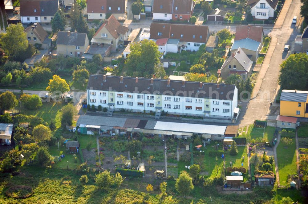 Osterburg from the bird's eye view: Mehrfamilienhaus an der Weinbergstraße Ecke Blesestraße mit Kleingartensiedlung vor dem Haus. Die Mehrfamilienhäuser dieser Art waren typische Reihenbauten zu DDR- Zeiten und wurden früher vor allen für Mitarbeiter von landwirtschaftlichen Betrieben errichtet. Multi-family house on the street corner Blesestraße vineyard with small garden in front of the settlement house. The multi-family houses of this kind were typical for GDR times.