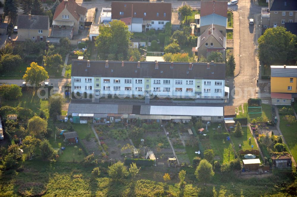 Aerial image Osterburg - Mehrfamilienhaus an der Weinbergstraße Ecke Blesestraße mit Kleingartensiedlung vor dem Haus. Die Mehrfamilienhäuser dieser Art waren typische Reihenbauten zu DDR- Zeiten und wurden früher vor allen für Mitarbeiter von landwirtschaftlichen Betrieben errichtet. Multi-family house on the street corner Blesestraße vineyard with small garden in front of the settlement house. The multi-family houses of this kind were typical for GDR times.