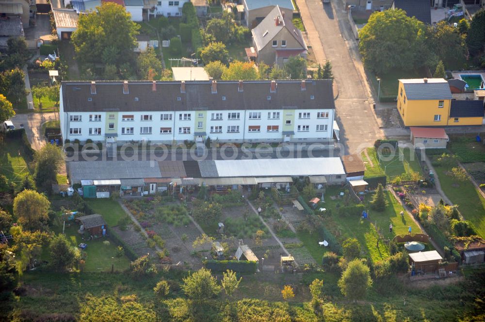 Aerial photograph Osterburg - Mehrfamilienhaus an der Weinbergstraße Ecke Blesestraße mit Kleingartensiedlung vor dem Haus. Die Mehrfamilienhäuser dieser Art waren typische Reihenbauten zu DDR- Zeiten und wurden früher vor allen für Mitarbeiter von landwirtschaftlichen Betrieben errichtet. Multi-family house on the street corner Blesestraße vineyard with small garden in front of the settlement house. The multi-family houses of this kind were typical for GDR times.