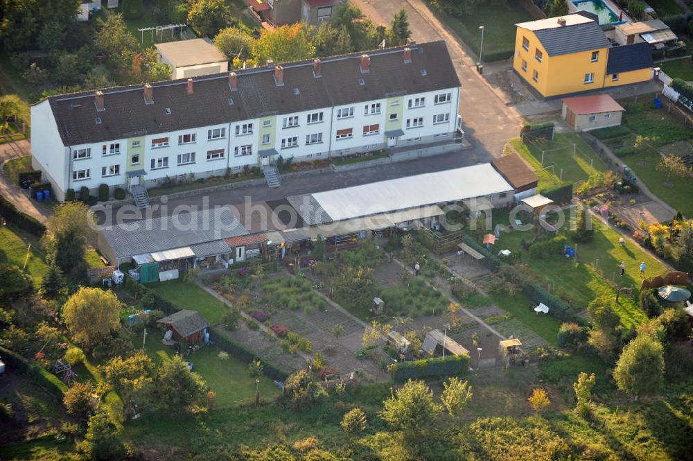 Osterburg from the bird's eye view: Mehrfamilienhaus an der Weinbergstraße Ecke Blesestraße mit Kleingartensiedlung vor dem Haus. Die Mehrfamilienhäuser dieser Art waren typische Reihenbauten zu DDR- Zeiten und wurden früher vor allen für Mitarbeiter von landwirtschaftlichen Betrieben errichtet. Multi-family house on the street corner Blesestraße vineyard with small garden in front of the settlement house. The multi-family houses of this kind were typical for GDR times.