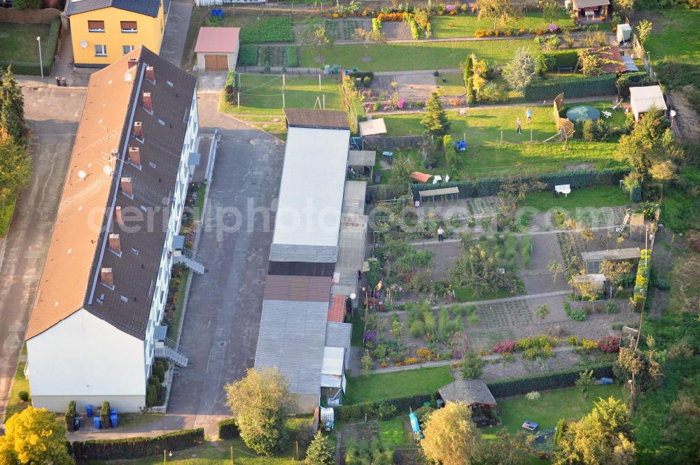 Aerial photograph Osterburg - Mehrfamilienhaus an der Weinbergstraße Ecke Blesestraße mit Kleingartensiedlung vor dem Haus. Die Mehrfamilienhäuser dieser Art waren typische Reihenbauten zu DDR- Zeiten und wurden früher vor allen für Mitarbeiter von landwirtschaftlichen Betrieben errichtet. Multi-family house on the street corner Blesestraße vineyard with small garden in front of the settlement house. The multi-family houses of this kind were typical for GDR times.