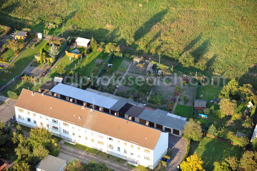 Osterburg from the bird's eye view: Mehrfamilienhaus an der Weinbergstraße Ecke Blesestraße mit Kleingartensiedlung vor dem Haus. Die Mehrfamilienhäuser dieser Art waren typische Reihenbauten zu DDR- Zeiten und wurden früher vor allen für Mitarbeiter von landwirtschaftlichen Betrieben errichtet. Multi-family house on the street corner Blesestraße vineyard with small garden in front of the settlement house. The multi-family houses of this kind were typical for GDR times.