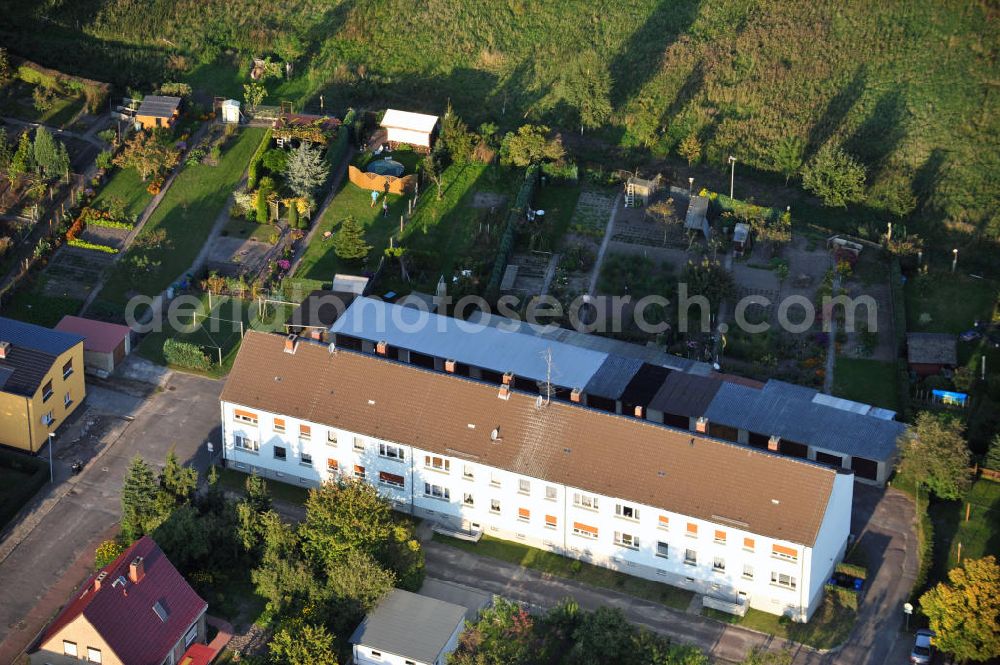 Aerial image Osterburg - Mehrfamilienhaus an der Weinbergstraße Ecke Blesestraße mit Kleingartensiedlung vor dem Haus. Die Mehrfamilienhäuser dieser Art waren typische Reihenbauten zu DDR- Zeiten und wurden früher vor allen für Mitarbeiter von landwirtschaftlichen Betrieben errichtet. Multi-family house on the street corner Blesestraße vineyard with small garden in front of the settlement house. The multi-family houses of this kind were typical for GDR times.