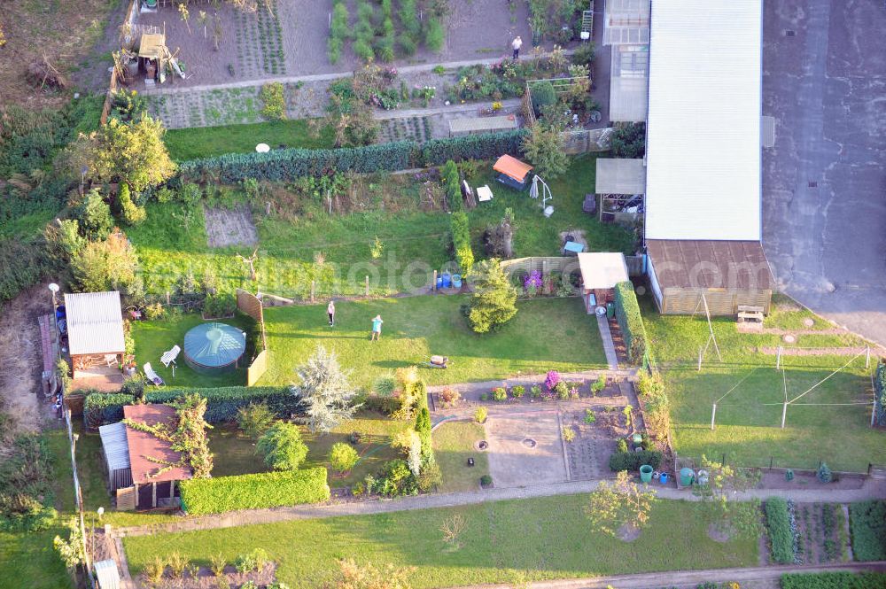 Aerial photograph Osterburg - Mehrfamilienhaus an der Weinbergstraße Ecke Blesestraße mit Kleingartensiedlung vor dem Haus. Die Mehrfamilienhäuser dieser Art waren typische Reihenbauten zu DDR- Zeiten und wurden früher vor allen für Mitarbeiter von landwirtschaftlichen Betrieben errichtet. Multi-family house on the street corner Blesestraße vineyard with small garden in front of the settlement house. The multi-family houses of this kind were typical for GDR times.