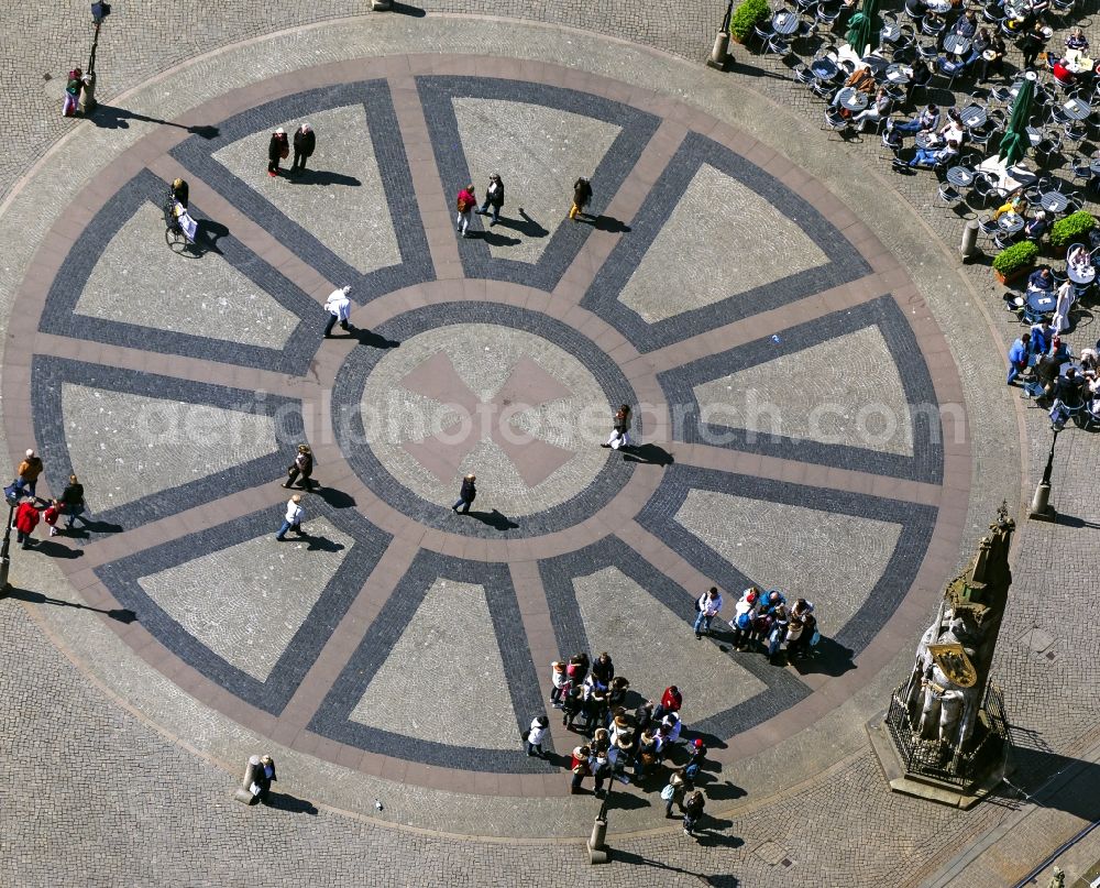 Bremen from above - View at tables of cafés around the market place in Bremen in front of the statue Bremer Roland. The ground is paved with the Hanseat Cross