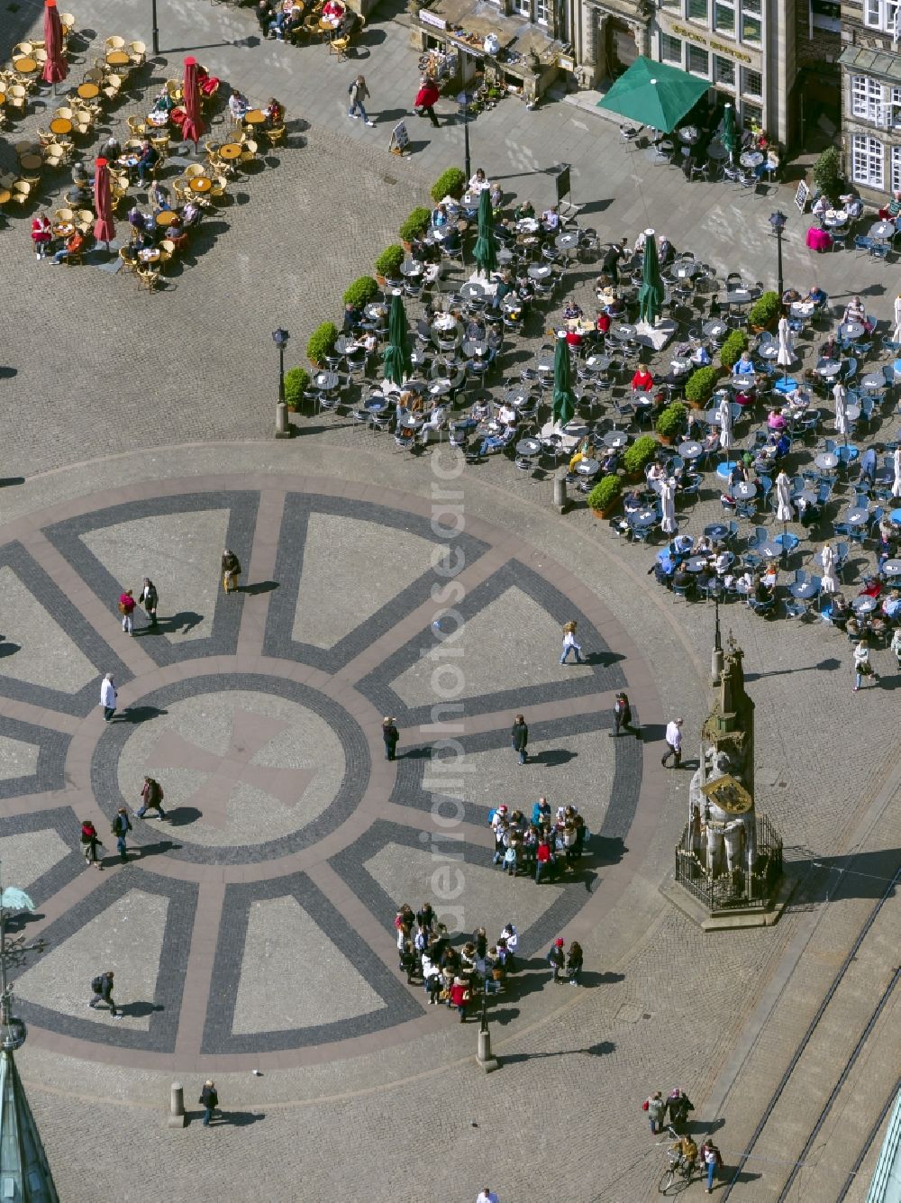 Aerial photograph Bremen - View at tables of cafés around the market place in Bremen in front of the statue Bremer Roland. The ground is paved with the Hanseat Cross