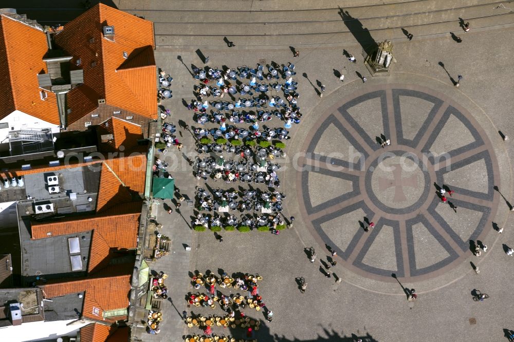 Aerial photograph Bremen - View at tables of cafés around the market place in Bremen in front of the statue Bremer Roland. The ground is paved with the Hanseat Cross