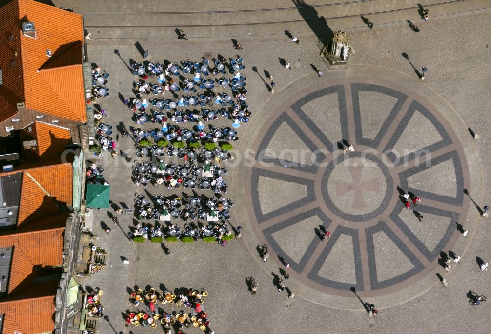 Bremen from above - View at tables of cafés around the market place in Bremen in front of the statue Bremer Roland. The ground is paved with the Hanseat Cross