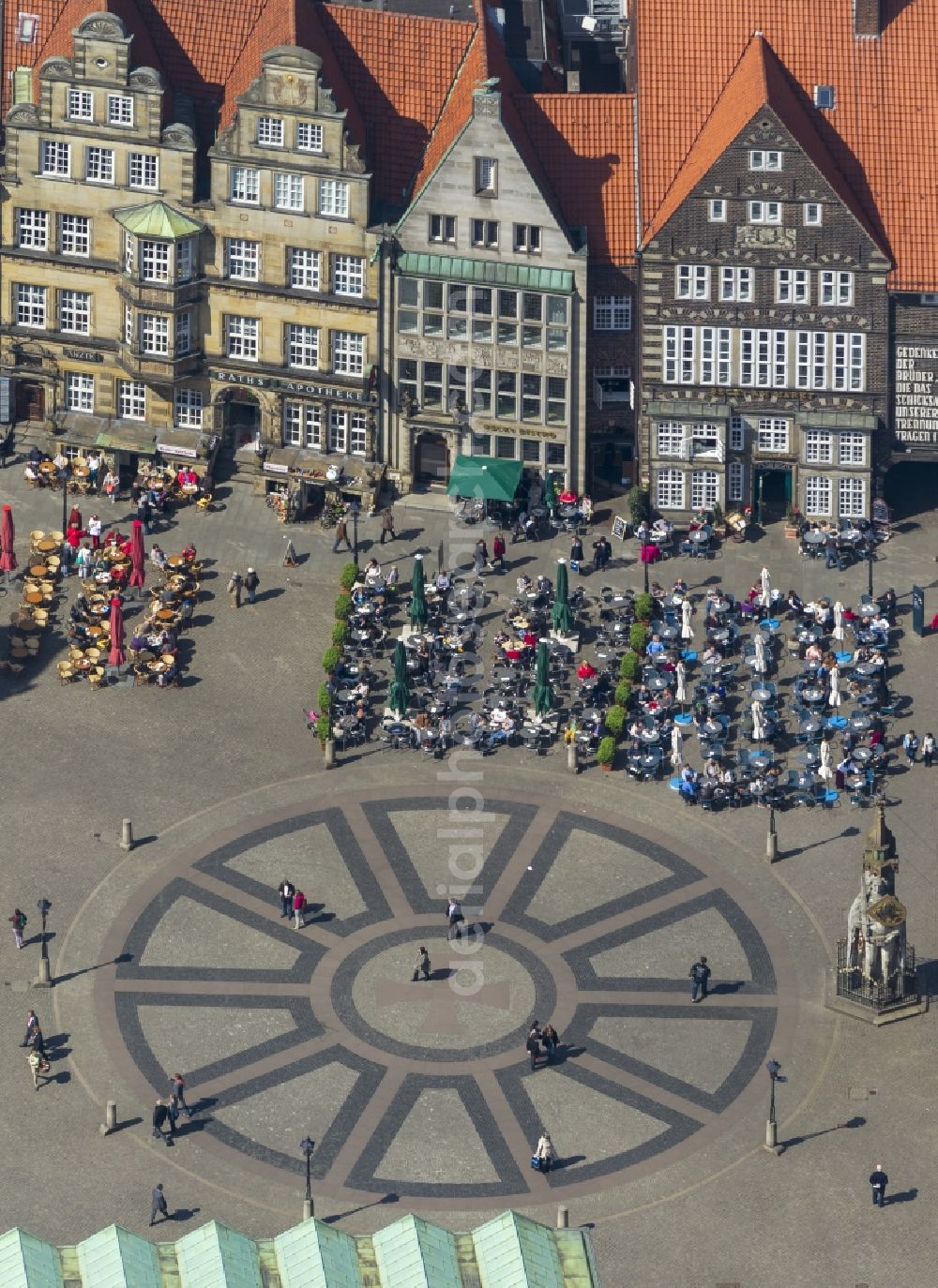 Bremen from above - View at tables of cafés around the market place in Bremen in front of the statue Bremer Roland. The ground is paved with the Hanseat Cross