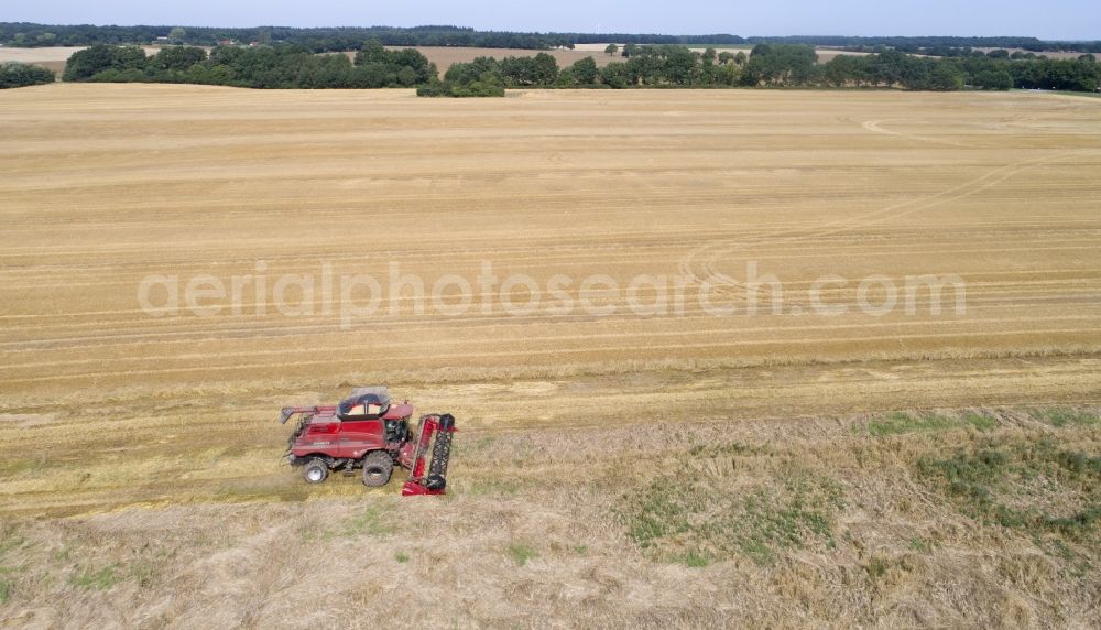 Zapel from above - Harvester-thresher on a grain field at harvest time in Zapel in the state Mecklenburg - Western Pomerania, Germany