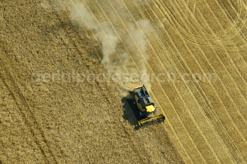 Rauschwitz from the bird's eye view: Combines an agricultural concern at harvest on a grain field in Rauschwitz in Thuringia