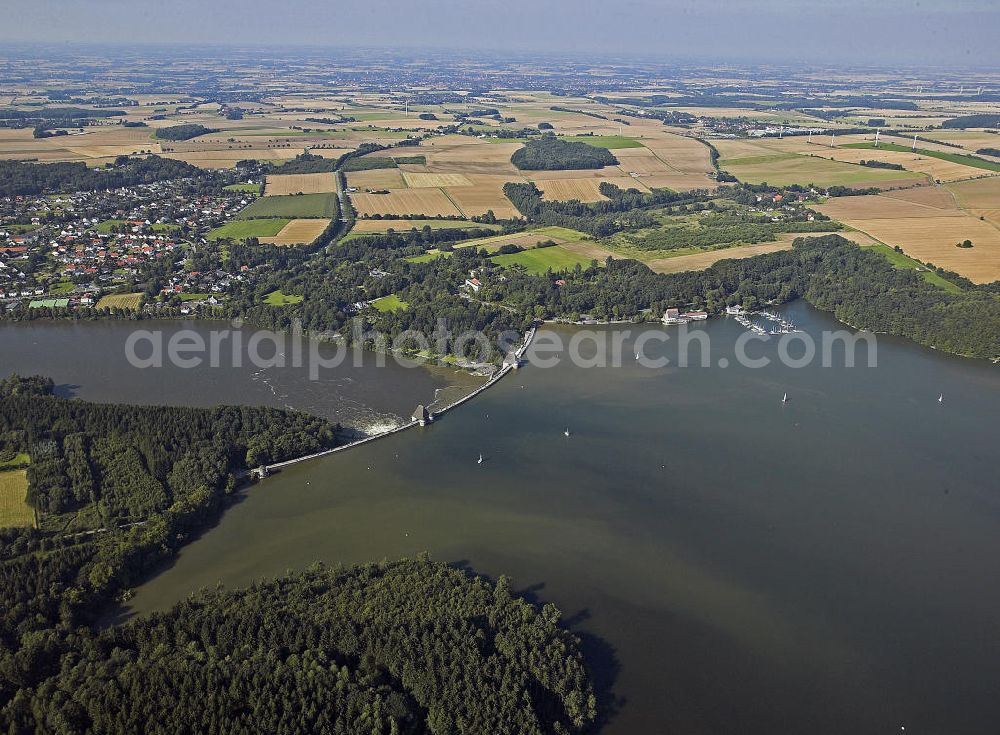 Möhnesee from the bird's eye view: Blick auf die Möhnetalsperre mit Staumauer und Stausee während des Hochwassers 2007. Die Talsperre wurde zwischen 1908 und 1913 erbaut und umfasst rund 134,5 Millionen Kubikmeter Wasser. Die Mauer hat eine Kronenlänge von 650 m und eine Höhe von insgesamt 215 m. View of the dam and reservoir of the Moehne barrage during the flood 2007. The dam was built between 1908 and 1913 and the reservoir comprises approximately 134.5 million cubic meters of water. It has a crest length of 650 m and a height of 215 m.