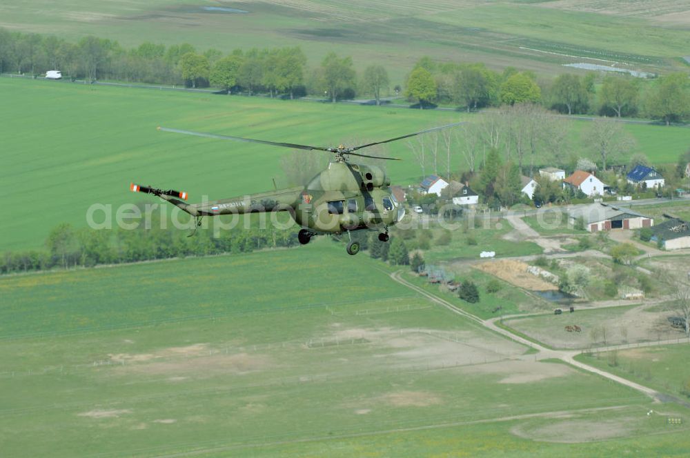 Finow from above - MI-2 Helikopter in Bemalung der ehemaligen NVA-Luftstreitkräfte (Nationale Volksarmee) der DDR mit noch am Rumpf sichtbarer taktischer Nummer der Bundeswehr im Anflug auf den Flugplatz Finow / Eberswalde zum historischen Oldtimertreffen auf dem Freigelände der Luftfahrthistorischen Sammlung. Das Luftfahrzeug fliegt heute unter der russischen Kennung RA-3314 K.