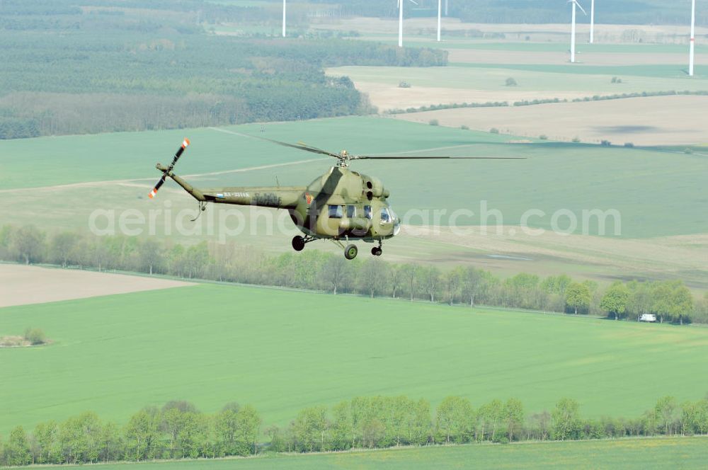 Aerial image Finow - MI-2 Helikopter in Bemalung der ehemaligen NVA-Luftstreitkräfte (Nationale Volksarmee) der DDR mit noch am Rumpf sichtbarer taktischer Nummer der Bundeswehr im Anflug auf den Flugplatz Finow / Eberswalde zum historischen Oldtimertreffen auf dem Freigelände der Luftfahrthistorischen Sammlung. Das Luftfahrzeug fliegt heute unter der russischen Kennung RA-3314 K.