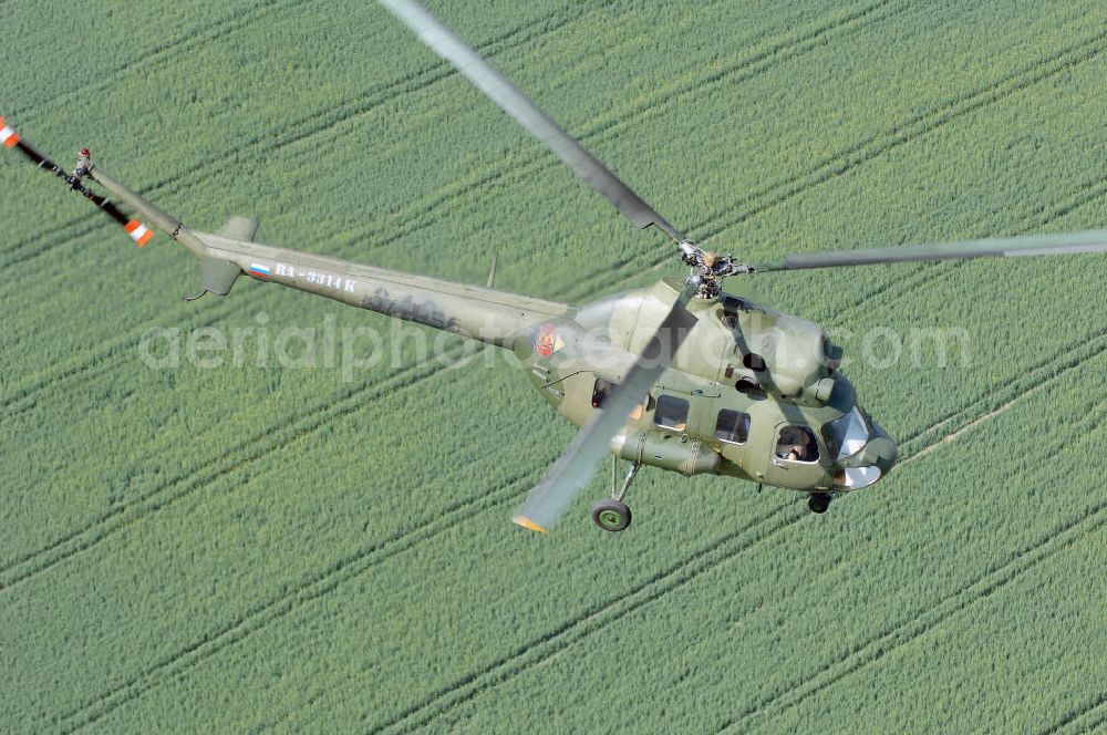 Aerial image Finow - MI-2 Helikopter in Bemalung der ehemaligen NVA-Luftstreitkräfte (Nationale Volksarmee) der DDR mit noch am Rumpf sichtbarer taktischer Nummer der Bundeswehr im Anflug auf den Flugplatz Finow / Eberswalde zum historischen Oldtimertreffen auf dem Freigelände der Luftfahrthistorischen Sammlung. Das Luftfahrzeug fliegt heute unter der russischen Kennung RA-3314 K.