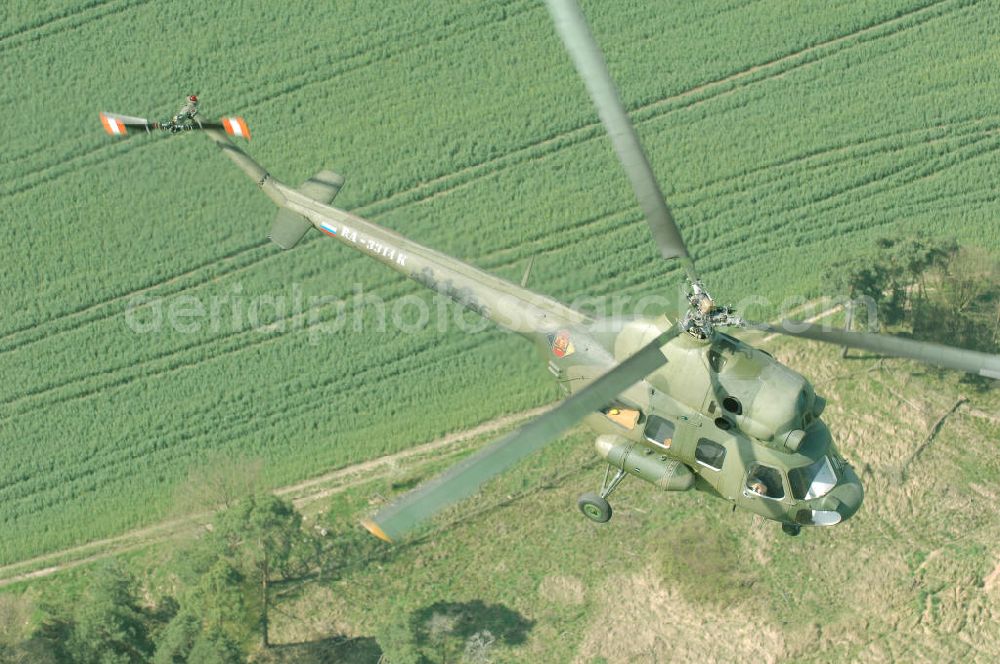 Finow from above - MI-2 Helikopter in Bemalung der ehemaligen NVA-Luftstreitkräfte (Nationale Volksarmee) der DDR mit noch am Rumpf sichtbarer taktischer Nummer der Bundeswehr im Anflug auf den Flugplatz Finow / Eberswalde zum historischen Oldtimertreffen auf dem Freigelände der Luftfahrthistorischen Sammlung. Das Luftfahrzeug fliegt heute unter der russischen Kennung RA-3314 K.