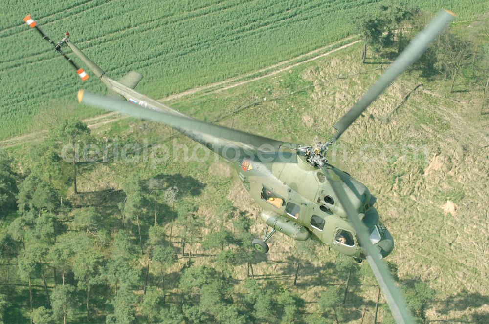 Finow from the bird's eye view: MI-2 Helikopter in Bemalung der ehemaligen NVA-Luftstreitkräfte (Nationale Volksarmee) der DDR mit noch am Rumpf sichtbarer taktischer Nummer der Bundeswehr im Anflug auf den Flugplatz Finow / Eberswalde zum historischen Oldtimertreffen auf dem Freigelände der Luftfahrthistorischen Sammlung. Das Luftfahrzeug fliegt heute unter der russischen Kennung RA-3314 K.