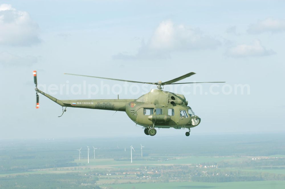 Aerial image Finow - MI-2 Helikopter in Bemalung der ehemaligen NVA-Luftstreitkräfte (Nationale Volksarmee) der DDR mit noch am Rumpf sichtbarer taktischer Nummer der Bundeswehr im Anflug auf den Flugplatz Finow / Eberswalde zum historischen Oldtimertreffen auf dem Freigelände der Luftfahrthistorischen Sammlung. Das Luftfahrzeug fliegt heute unter der russischen Kennung RA-3314 K.