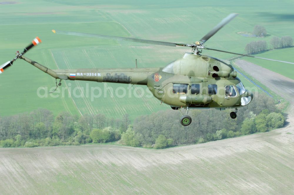 Finow from above - MI-2 Helikopter in Bemalung der ehemaligen NVA-Luftstreitkräfte (Nationale Volksarmee) der DDR mit noch am Rumpf sichtbarer taktischer Nummer der Bundeswehr im Anflug auf den Flugplatz Finow / Eberswalde zum historischen Oldtimertreffen auf dem Freigelände der Luftfahrthistorischen Sammlung. Das Luftfahrzeug fliegt heute unter der russischen Kennung RA-3314 K.