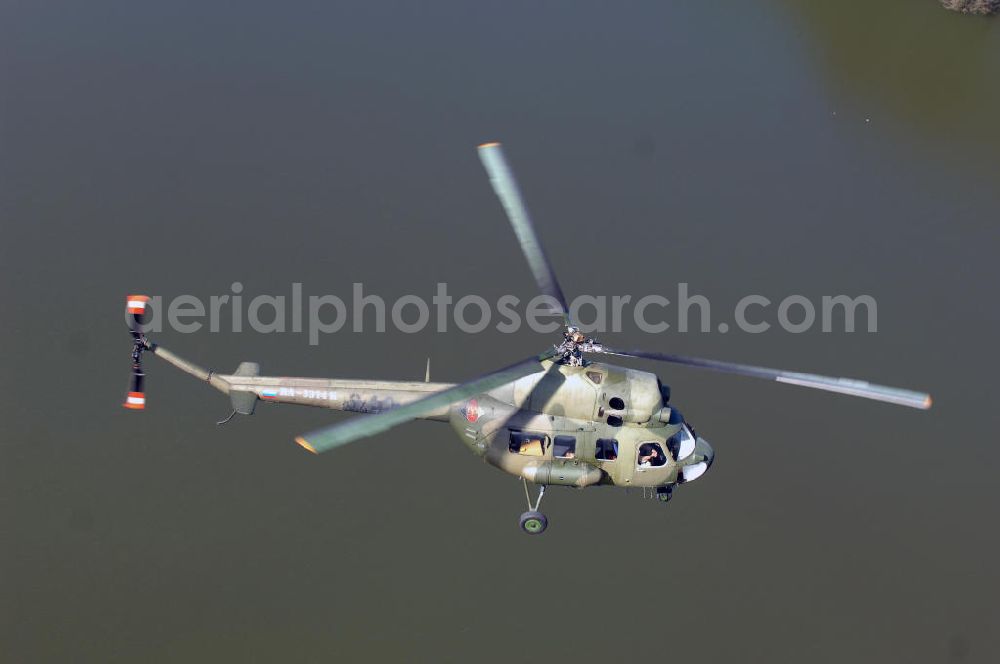 Aerial image Finow - MI-2 Helikopter in Bemalung der ehemaligen NVA-Luftstreitkräfte (Nationale Volksarmee) der DDR mit noch am Rumpf sichtbarer taktischer Nummer der Bundeswehr im Anflug auf den Flugplatz Finow / Eberswalde zum historischen Oldtimertreffen auf dem Freigelände der Luftfahrthistorischen Sammlung. Das Luftfahrzeug fliegt heute unter der russischen Kennung RA-3314 K.