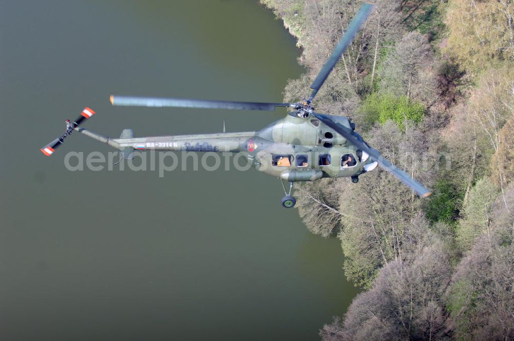 Finow from above - MI-2 Helikopter in Bemalung der ehemaligen NVA-Luftstreitkräfte (Nationale Volksarmee) der DDR mit noch am Rumpf sichtbarer taktischer Nummer der Bundeswehr im Anflug auf den Flugplatz Finow / Eberswalde zum historischen Oldtimertreffen auf dem Freigelände der Luftfahrthistorischen Sammlung. Das Luftfahrzeug fliegt heute unter der russischen Kennung RA-3314 K.