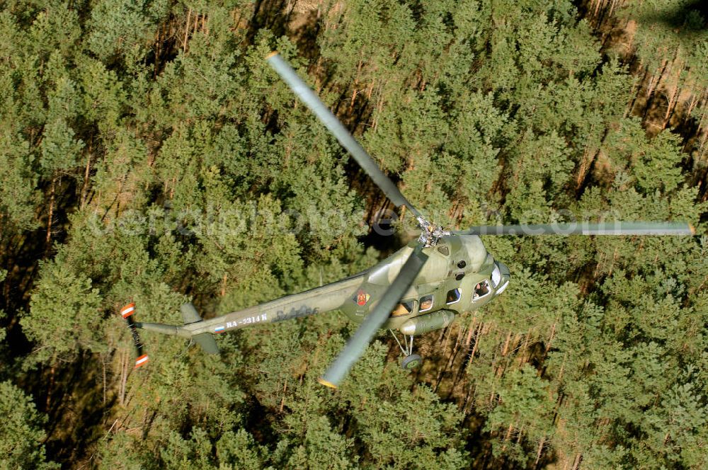 Aerial image Finow - MI-2 Helikopter in Bemalung der ehemaligen NVA-Luftstreitkräfte (Nationale Volksarmee) der DDR mit noch am Rumpf sichtbarer taktischer Nummer der Bundeswehr im Anflug auf den Flugplatz Finow / Eberswalde zum historischen Oldtimertreffen auf dem Freigelände der Luftfahrthistorischen Sammlung. Das Luftfahrzeug fliegt heute unter der russischen Kennung RA-3314 K.