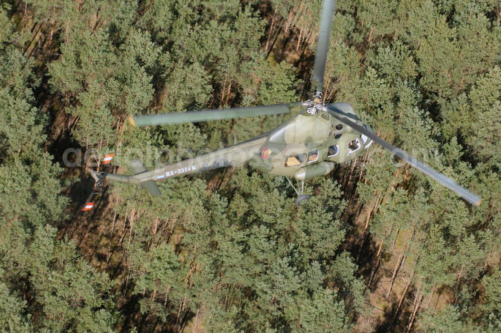 Aerial photograph Finow - MI-2 Helikopter in Bemalung der ehemaligen NVA-Luftstreitkräfte (Nationale Volksarmee) der DDR mit noch am Rumpf sichtbarer taktischer Nummer der Bundeswehr im Anflug auf den Flugplatz Finow / Eberswalde zum historischen Oldtimertreffen auf dem Freigelände der Luftfahrthistorischen Sammlung. Das Luftfahrzeug fliegt heute unter der russischen Kennung RA-3314 K.