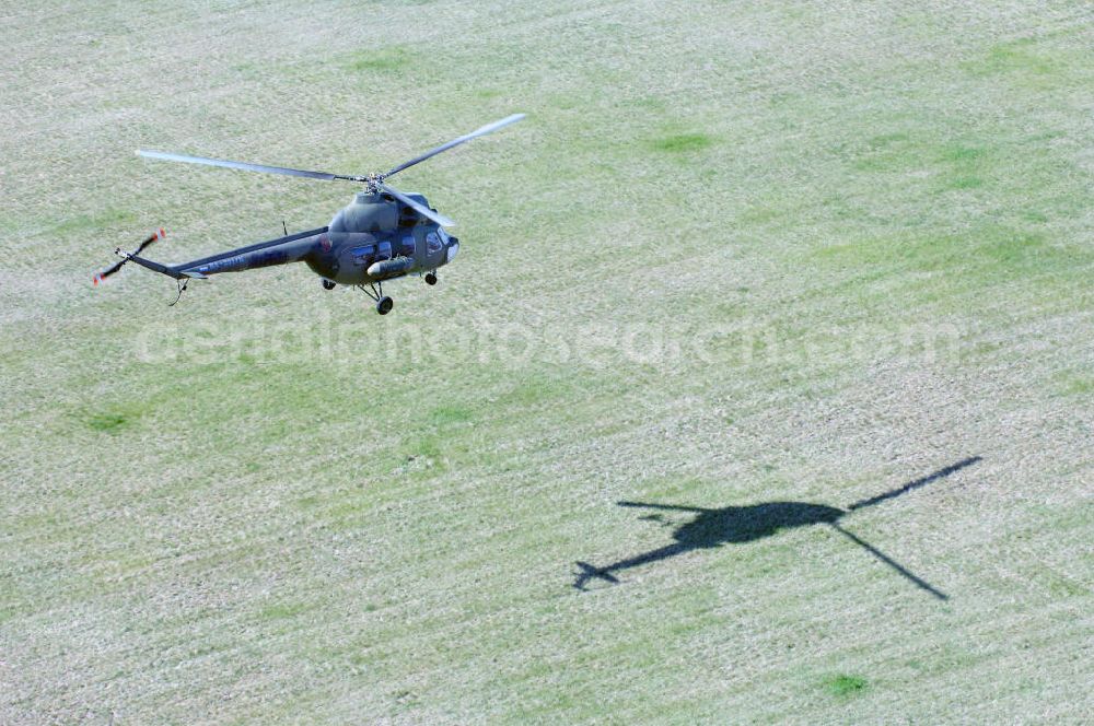 Finow from the bird's eye view: MI-2 Helikopter in Bemalung der ehemaligen NVA-Luftstreitkräfte (Nationale Volksarmee) der DDR mit noch am Rumpf sichtbarer taktischer Nummer der Bundeswehr im Anflug auf den Flugplatz Finow / Eberswalde zum historischen Oldtimertreffen auf dem Freigelände der Luftfahrthistorischen Sammlung. Das Luftfahrzeug fliegt heute unter der russischen Kennung RA-3314 K.