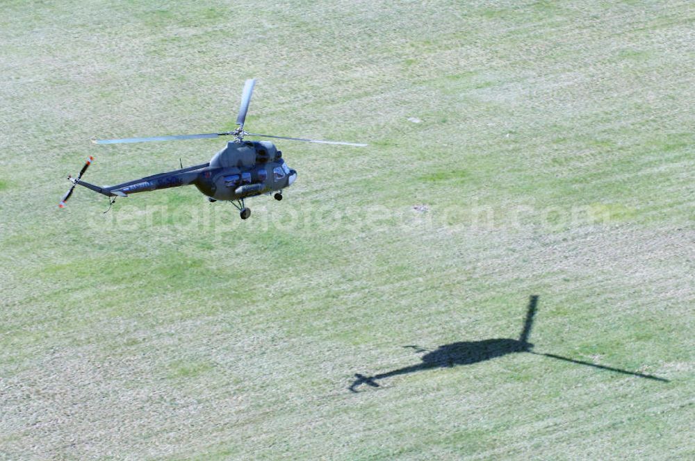 Aerial image Finow - MI-2 Helikopter in Bemalung der ehemaligen NVA-Luftstreitkräfte (Nationale Volksarmee) der DDR mit noch am Rumpf sichtbarer taktischer Nummer der Bundeswehr im Anflug auf den Flugplatz Finow / Eberswalde zum historischen Oldtimertreffen auf dem Freigelände der Luftfahrthistorischen Sammlung. Das Luftfahrzeug fliegt heute unter der russischen Kennung RA-3314 K.