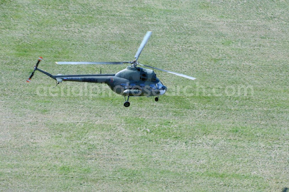 Aerial photograph Finow - MI-2 Helikopter in Bemalung der ehemaligen NVA-Luftstreitkräfte (Nationale Volksarmee) der DDR mit noch am Rumpf sichtbarer taktischer Nummer der Bundeswehr im Anflug auf den Flugplatz Finow / Eberswalde zum historischen Oldtimertreffen auf dem Freigelände der Luftfahrthistorischen Sammlung. Das Luftfahrzeug fliegt heute unter der russischen Kennung RA-3314 K.