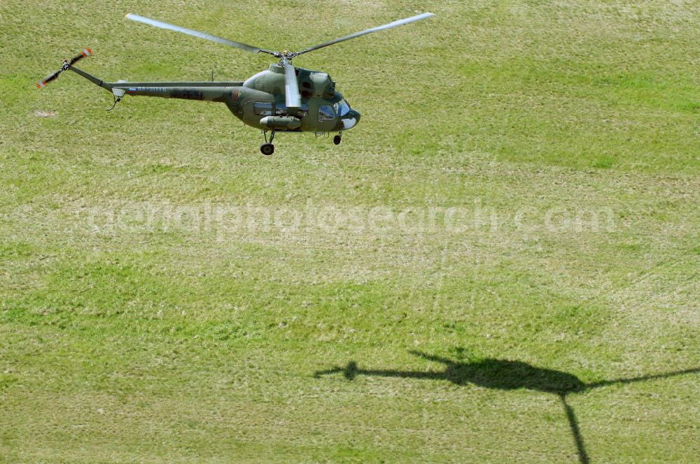 Finow from above - MI-2 Helikopter in Bemalung der ehemaligen NVA-Luftstreitkräfte (Nationale Volksarmee) der DDR mit noch am Rumpf sichtbarer taktischer Nummer der Bundeswehr im Anflug auf den Flugplatz Finow / Eberswalde zum historischen Oldtimertreffen auf dem Freigelände der Luftfahrthistorischen Sammlung. Das Luftfahrzeug fliegt heute unter der russischen Kennung RA-3314 K.