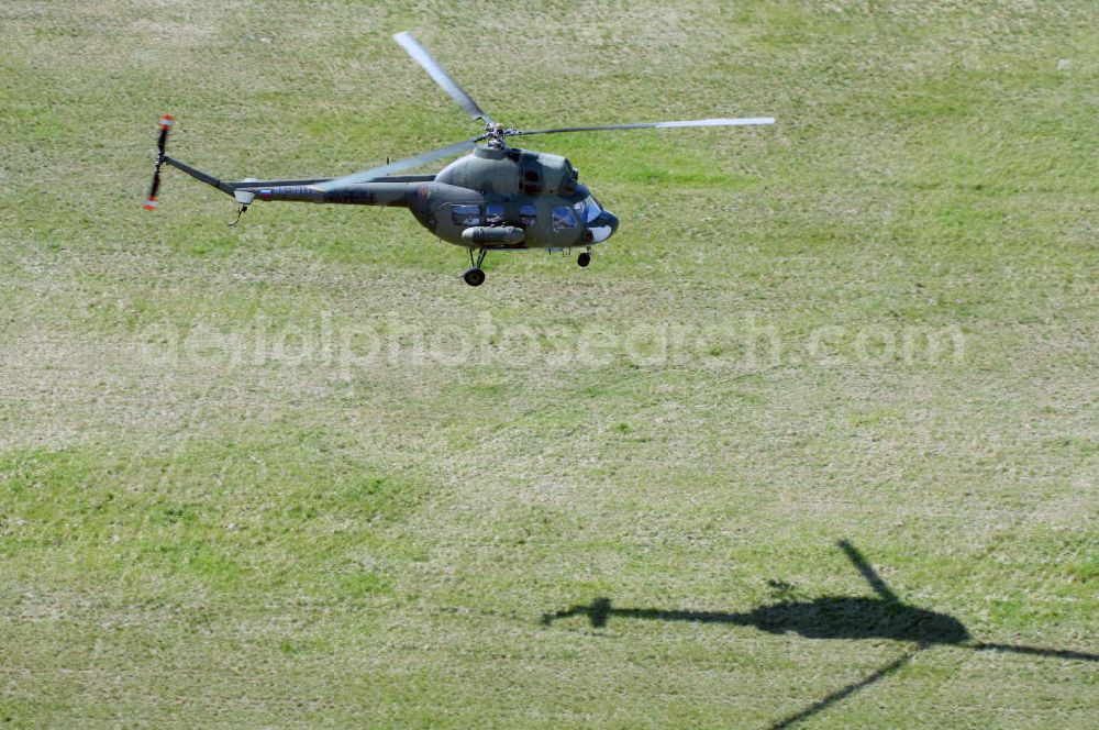 Finow from the bird's eye view: MI-2 Helikopter in Bemalung der ehemaligen NVA-Luftstreitkräfte (Nationale Volksarmee) der DDR mit noch am Rumpf sichtbarer taktischer Nummer der Bundeswehr im Anflug auf den Flugplatz Finow / Eberswalde zum historischen Oldtimertreffen auf dem Freigelände der Luftfahrthistorischen Sammlung. Das Luftfahrzeug fliegt heute unter der russischen Kennung RA-3314 K.