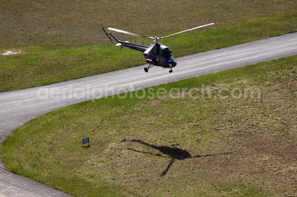 Aerial image Finow - MI-2 Helikopter in Bemalung der ehemaligen NVA-Luftstreitkräfte (Nationale Volksarmee) der DDR mit noch am Rumpf sichtbarer taktischer Nummer der Bundeswehr im Anflug auf den Flugplatz Finow / Eberswalde zum historischen Oldtimertreffen auf dem Freigelände der Luftfahrthistorischen Sammlung. Das Luftfahrzeug fliegt heute unter der russischen Kennung RA-3314 K.