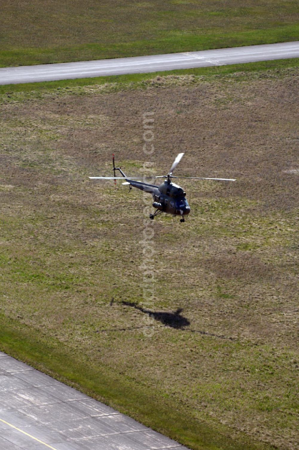 Aerial photograph Finow - MI-2 Helikopter in Bemalung der ehemaligen NVA-Luftstreitkräfte (Nationale Volksarmee) der DDR mit noch am Rumpf sichtbarer taktischer Nummer der Bundeswehr im Anflug auf den Flugplatz Finow / Eberswalde zum historischen Oldtimertreffen auf dem Freigelände der Luftfahrthistorischen Sammlung. Das Luftfahrzeug fliegt heute unter der russischen Kennung RA-3314 K.