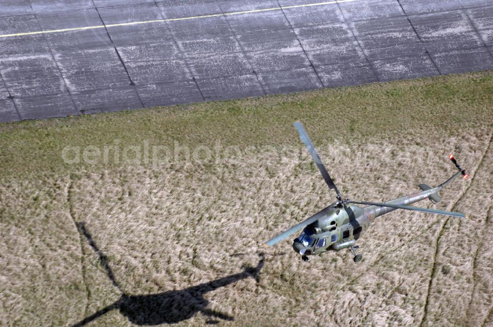 Finow from above - MI-2 Helikopter in Bemalung der ehemaligen NVA-Luftstreitkräfte (Nationale Volksarmee) der DDR mit noch am Rumpf sichtbarer taktischer Nummer der Bundeswehr im Anflug auf den Flugplatz Finow / Eberswalde zum historischen Oldtimertreffen auf dem Freigelände der Luftfahrthistorischen Sammlung. Das Luftfahrzeug fliegt heute unter der russischen Kennung RA-3314 K.