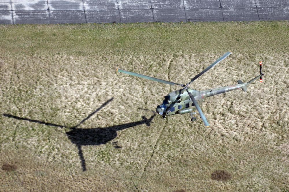 Finow from the bird's eye view: MI-2 Helikopter in Bemalung der ehemaligen NVA-Luftstreitkräfte (Nationale Volksarmee) der DDR mit noch am Rumpf sichtbarer taktischer Nummer der Bundeswehr im Anflug auf den Flugplatz Finow / Eberswalde zum historischen Oldtimertreffen auf dem Freigelände der Luftfahrthistorischen Sammlung. Das Luftfahrzeug fliegt heute unter der russischen Kennung RA-3314 K.