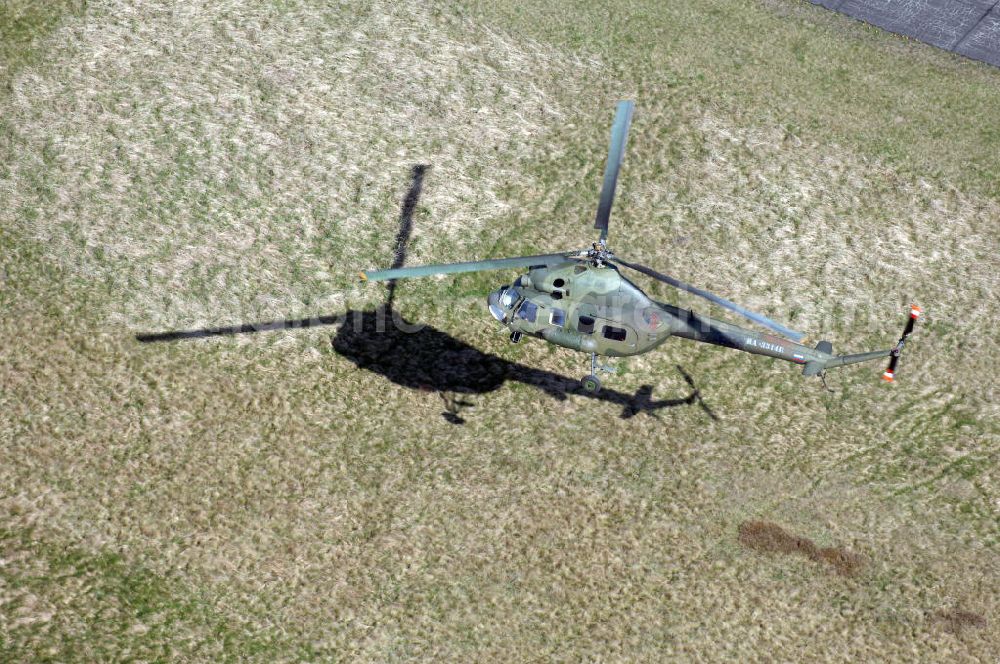 Aerial photograph Finow - MI-2 Helikopter in Bemalung der ehemaligen NVA-Luftstreitkräfte (Nationale Volksarmee) der DDR mit noch am Rumpf sichtbarer taktischer Nummer der Bundeswehr im Anflug auf den Flugplatz Finow / Eberswalde zum historischen Oldtimertreffen auf dem Freigelände der Luftfahrthistorischen Sammlung. Das Luftfahrzeug fliegt heute unter der russischen Kennung RA-3314 K.