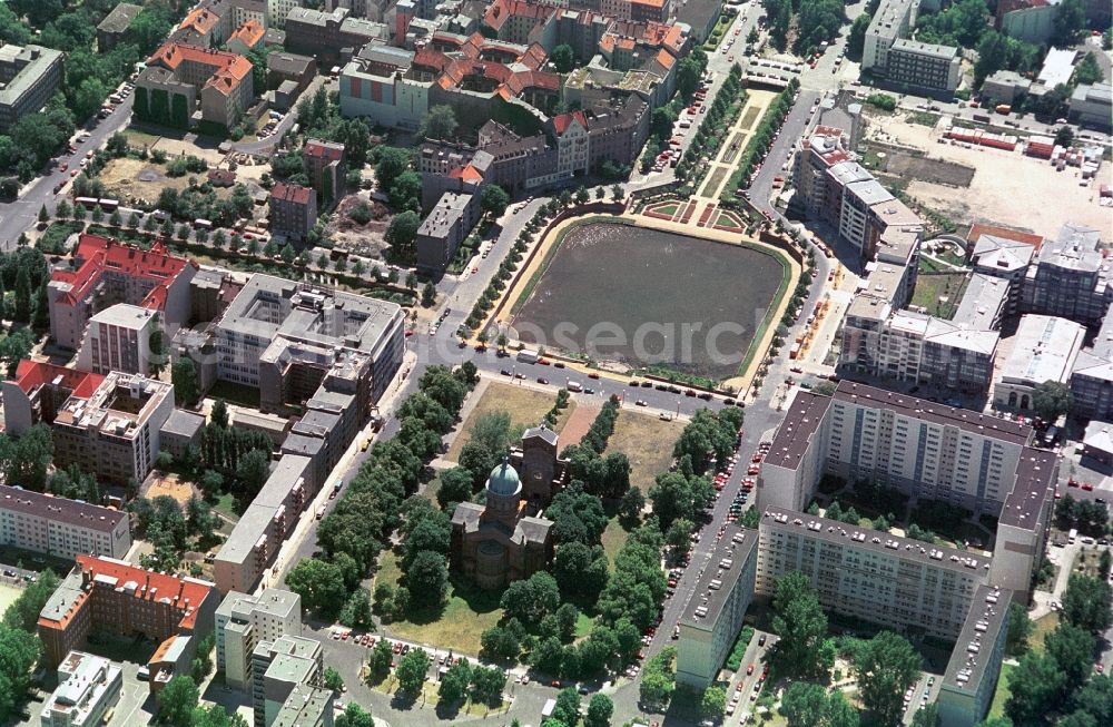 Aerial image Berlin - On the Michaelkirchplatz in Berlin-Mitte is the Catholic St. Michael's Church, which was built by the architect August Stuehler. Before the church is the angel pool that was once part of the Luisenstaedtischer channel, which was drained and now can be used as a park. On the left corner of the square stands the Grade II listed house of the German Transport Federation, which was built by the architect Bruno Taut