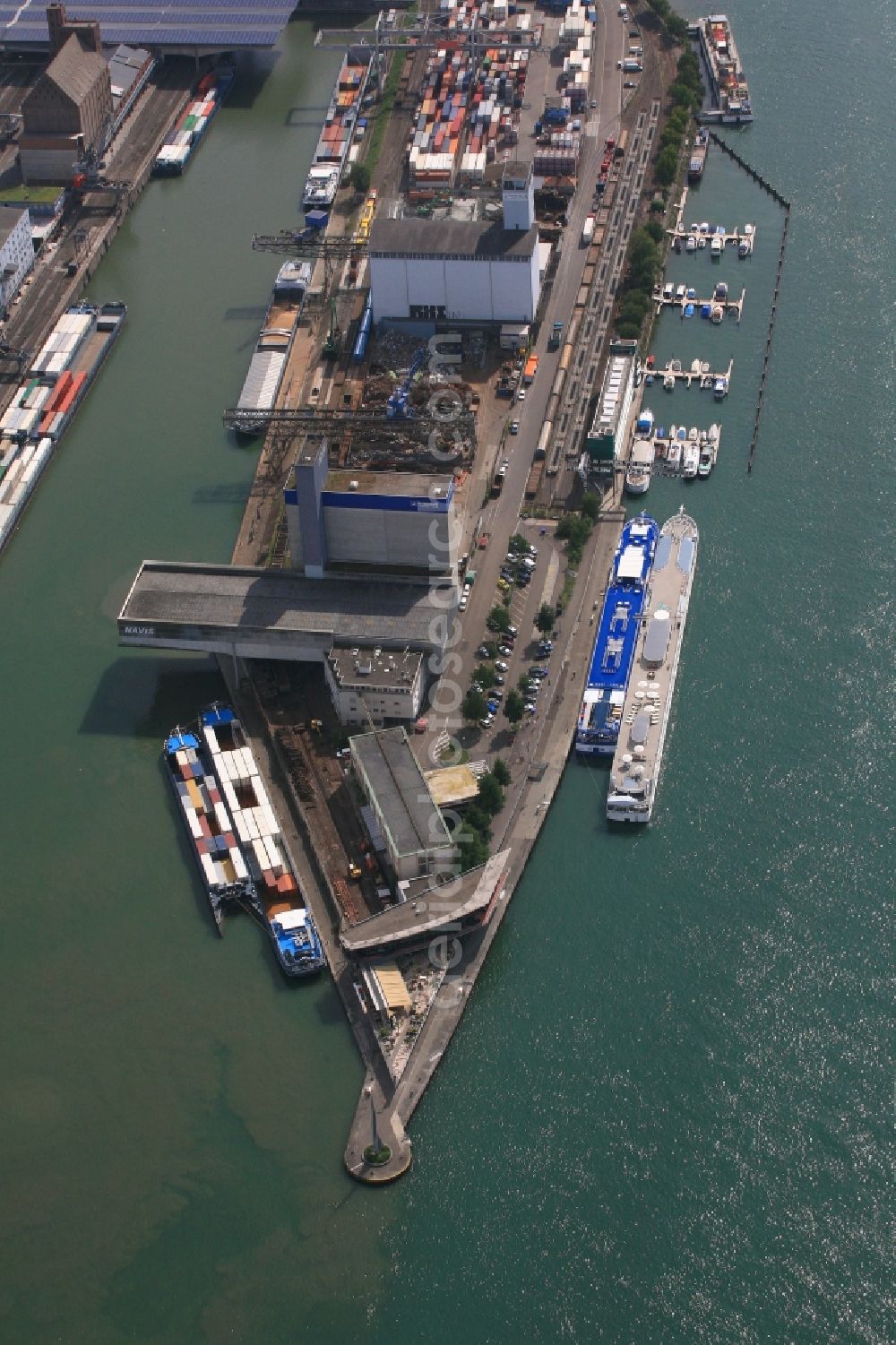 Basel from the bird's eye view: In the middle of the river Rhine the three countries Germany, Switzerland and France merge in Basel in Switzerland. A Pylon is symbolising the location in the harbor area of Basle in Switzerland