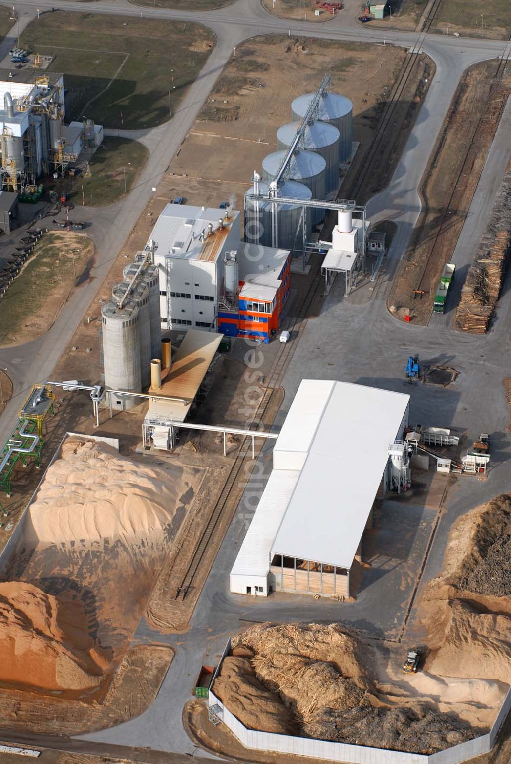 Aerial image Schwedt - Blick auf das neu errichtete Holzpelletierwerk auf dem Gelände der Raffenerie in Schwedt. Die Diersch & Schröder-Gruppe aus Bremen hat sich an der Holzkontor Ulf Mösenthin GmbH mehrheitlich beteiligt und betreibt unter dem neuen Namen Holzkontor und Pelletierwerk Schwedt GmbH Brandenburgs das Holzpelletierwerk in den neuen Bundesländern. Seit 2006 werden hier jährlich rund 100.000 t Holzpellets produziert. Das Unternehmen hati rund 12 Mio. Euro investiert und 25 Arbeitsplätze in Schwedt neu geschaffen. Partner des Unternehmens sind Ulf Mösenthin, Forstunternehmer aus Fürstenberg und die VIS NOVA GmbH, Bremen (Holding Erneuerbare Energien der Gruppe Diersch & Schröder). Errichtet wurde die Anlage durch MANN Engineering GmbH, Matthias-Erzberger-Strasse 34 in 56564 Neuwied.Ansprechpartner Herr Dr. Stefan Döring, 02631 3445610