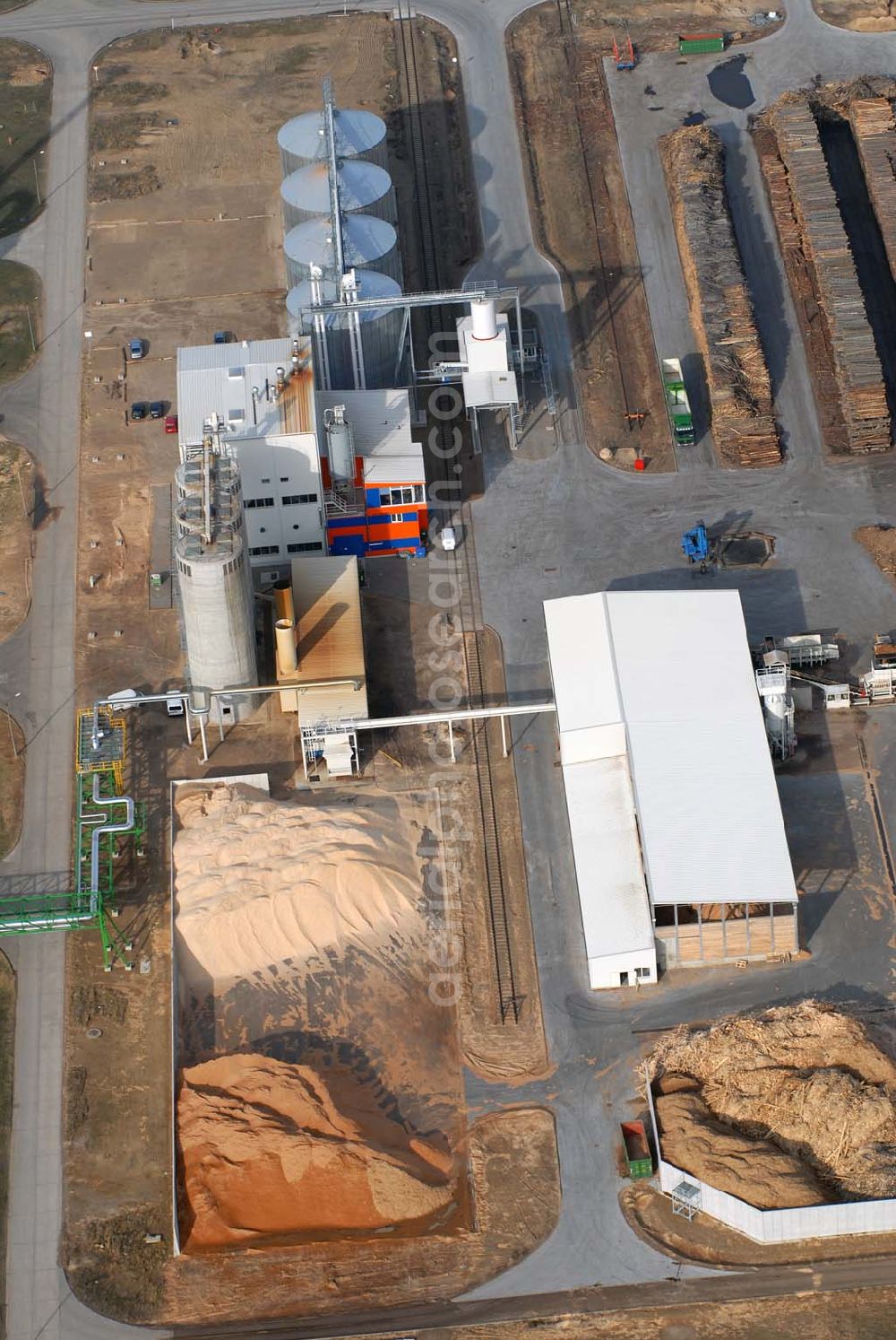 Aerial photograph Schwedt - Blick auf das neu errichtete Holzpelletierwerk auf dem Gelände der Raffenerie in Schwedt. Die Diersch & Schröder-Gruppe aus Bremen hat sich an der Holzkontor Ulf Mösenthin GmbH mehrheitlich beteiligt und betreibt unter dem neuen Namen Holzkontor und Pelletierwerk Schwedt GmbH Brandenburgs das Holzpelletierwerk in den neuen Bundesländern. Seit 2006 werden hier jährlich rund 100.000 t Holzpellets produziert. Das Unternehmen hati rund 12 Mio. Euro investiert und 25 Arbeitsplätze in Schwedt neu geschaffen. Partner des Unternehmens sind Ulf Mösenthin, Forstunternehmer aus Fürstenberg und die VIS NOVA GmbH, Bremen (Holding Erneuerbare Energien der Gruppe Diersch & Schröder). Errichtet wurde die Anlage durch MANN Engineering GmbH, Matthias-Erzberger-Strasse 34 in 56564 Neuwied.Ansprechpartner Herr Dr. Stefan Döring, 02631 3445610