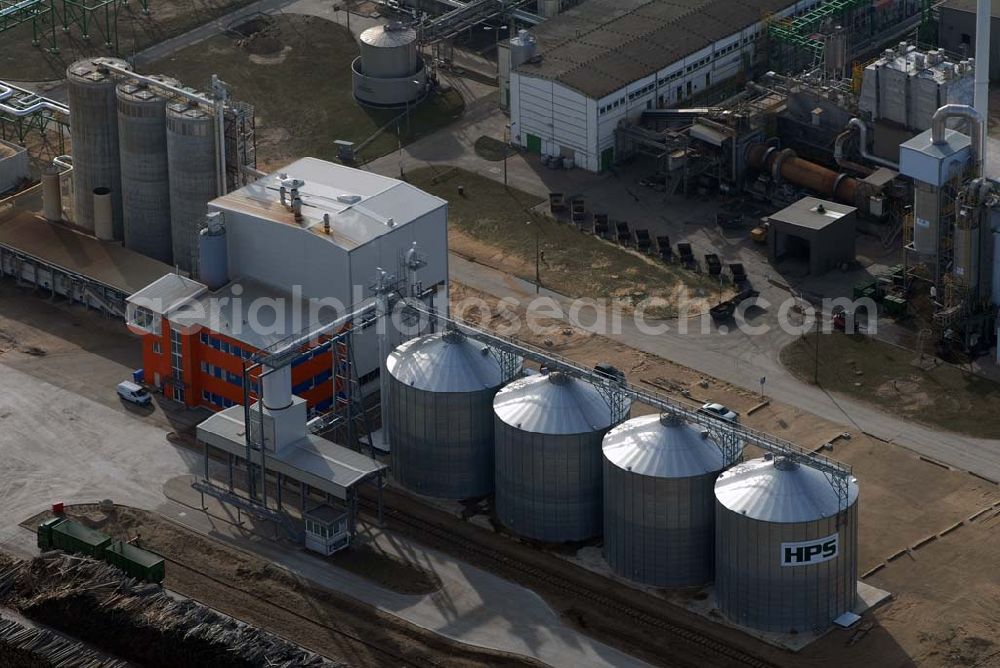 Aerial photograph Schwedt - Blick auf das neu errichtete Holzpelletierwerk auf dem Gelände der Raffenerie in Schwedt. Die Diersch & Schröder-Gruppe aus Bremen hat sich an der Holzkontor Ulf Mösenthin GmbH mehrheitlich beteiligt und betreibt unter dem neuen Namen Holzkontor und Pelletierwerk Schwedt GmbH Brandenburgs das Holzpelletierwerk in den neuen Bundesländern. Seit 2006 werden hier jährlich rund 100.000 t Holzpellets produziert. Das Unternehmen hati rund 12 Mio. Euro investiert und 25 Arbeitsplätze in Schwedt neu geschaffen. Partner des Unternehmens sind Ulf Mösenthin, Forstunternehmer aus Fürstenberg und die VIS NOVA GmbH, Bremen (Holding Erneuerbare Energien der Gruppe Diersch & Schröder). Errichtet wurde die Anlage durch MANN Engineering GmbH, Matthias-Erzberger-Strasse 34 in 56564 Neuwied.Ansprechpartner Herr Dr. Stefan Döring, 02631 3445610