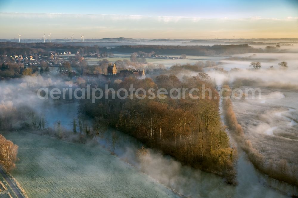 Hamm OT HEESEN from the bird's eye view: Morning fog backlit at sunrise on the water castle and former knight seat lock Heessen in its namesake district of Hamm in North Rhine-Westphalia