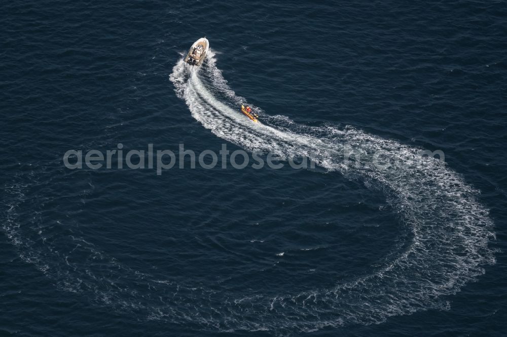 Pelzerhaken from above - Motorboat - Speedboat driving with a banana boat in tow on the Baltic Sea near Pelzerhaken in the state Schleswig-Holstein, Germany