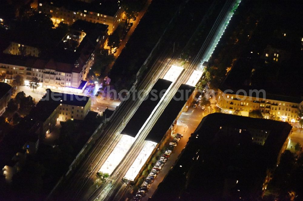 Aerial image Berlin - Night view Station building and track systems of the suburban train station Baumschulenweg of the S-Bahn Berlin GmbH in Berlin