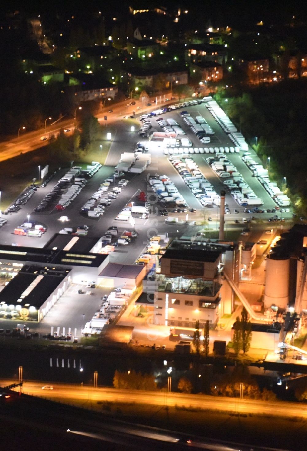 Berlin from above - Night aerial view on the Infocenter of the RWE Energiedienstleistungen GmbH with a combined heat and power station and parking lots in the Rudow district of Berlin