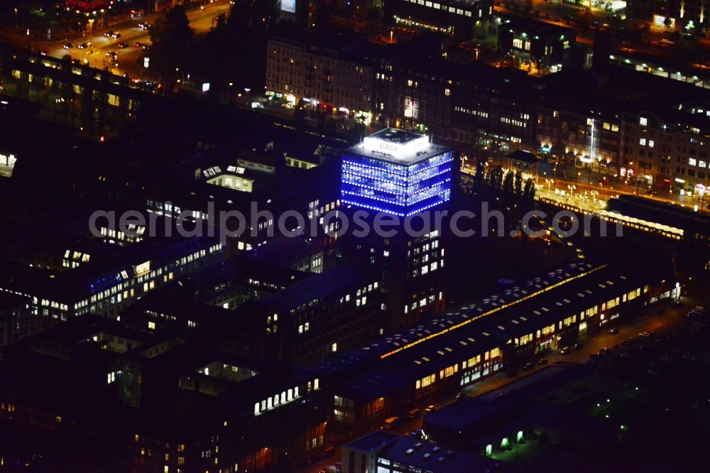 Aerial photograph Berlin - Nightly illuminated office tower in the Oberbaum city at the subway station Warschauer Strasse in the district Friedrichshain in Berlin